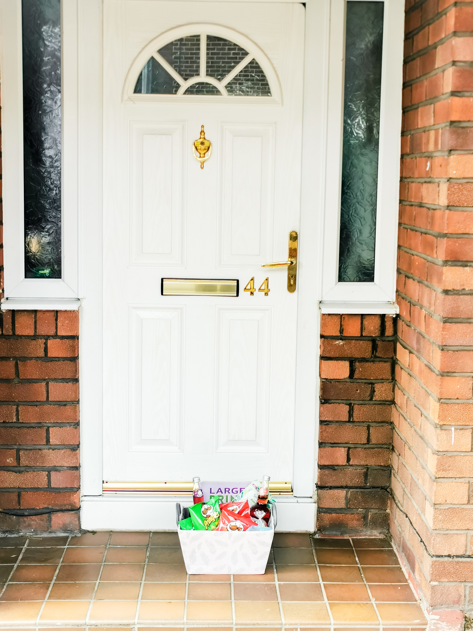 closed white front door with a gift basket in front of it