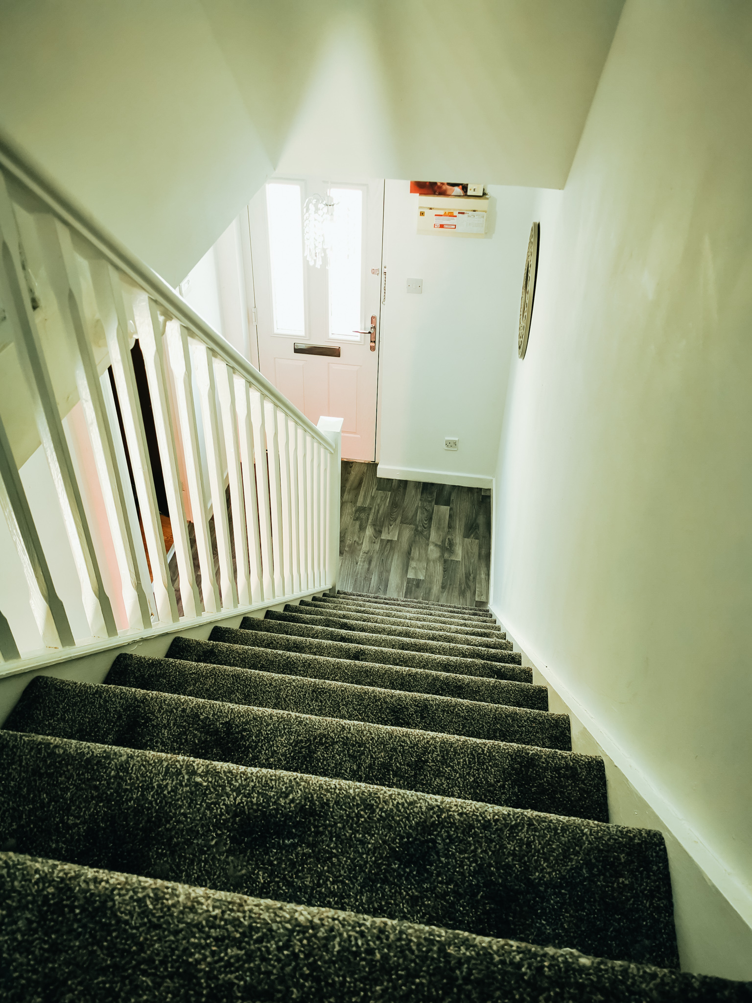 shot of stairs and hallway with grey carpets and white walls