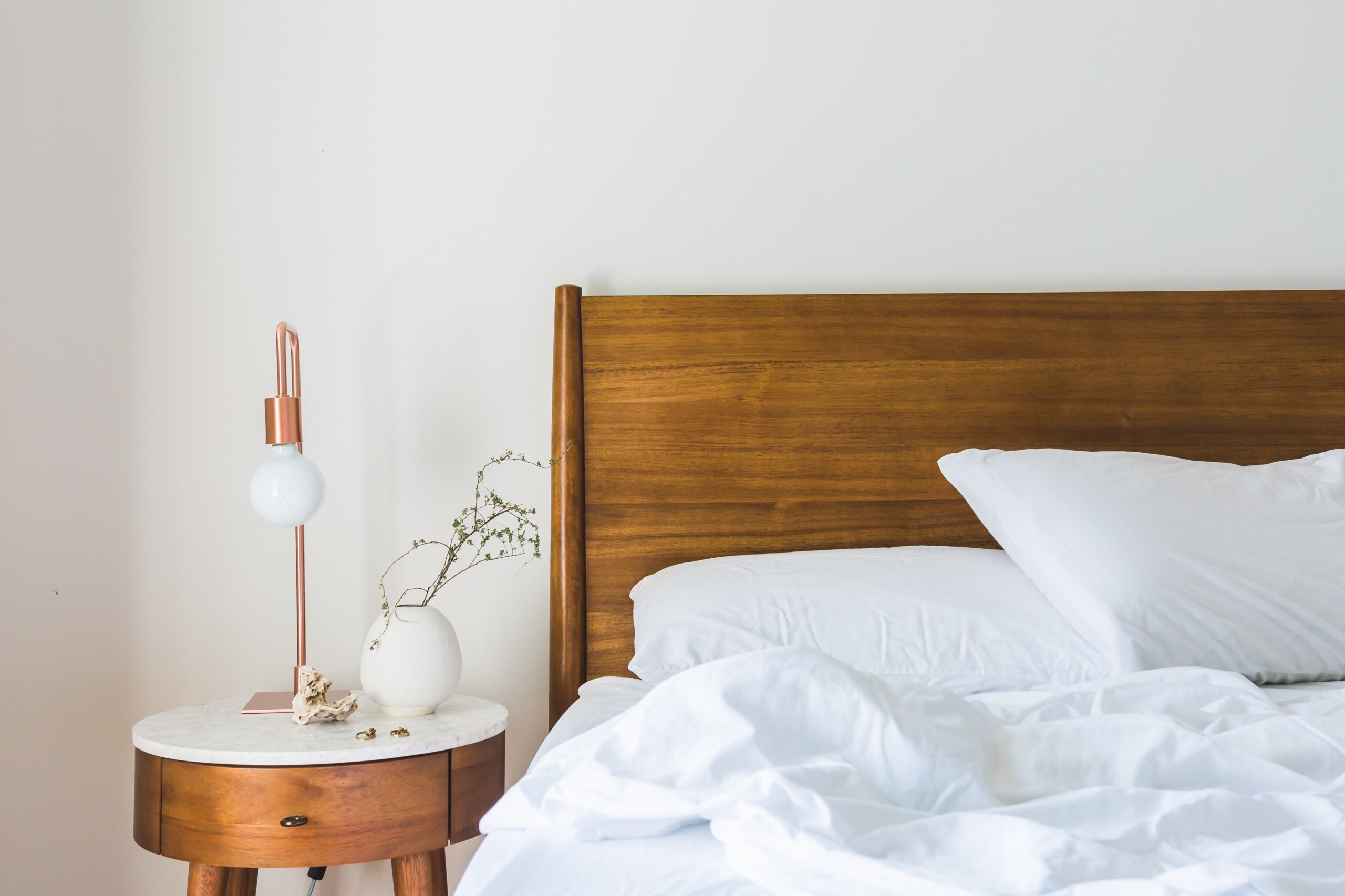 messy bed with wooden headboard