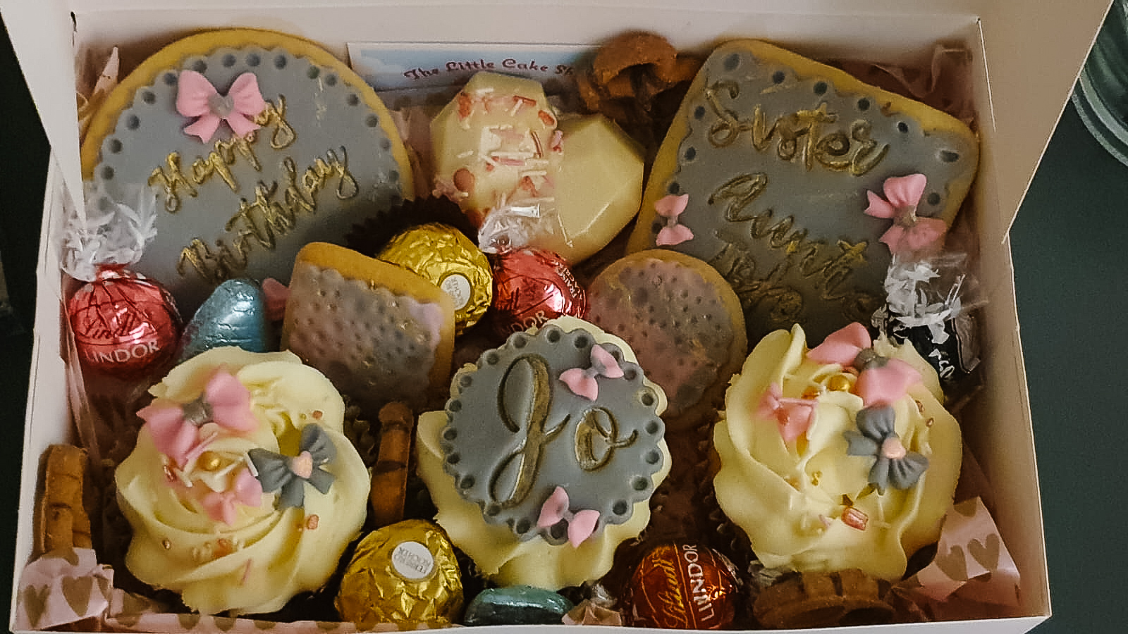 assorted cupcakes and biscuits in a gift box intricately decorated