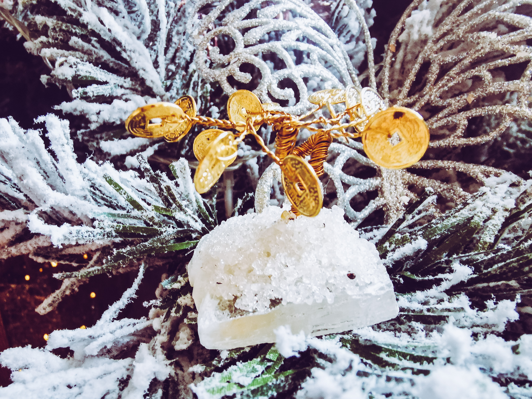 close up of a small gold moeny tree ornament in a christmas tree