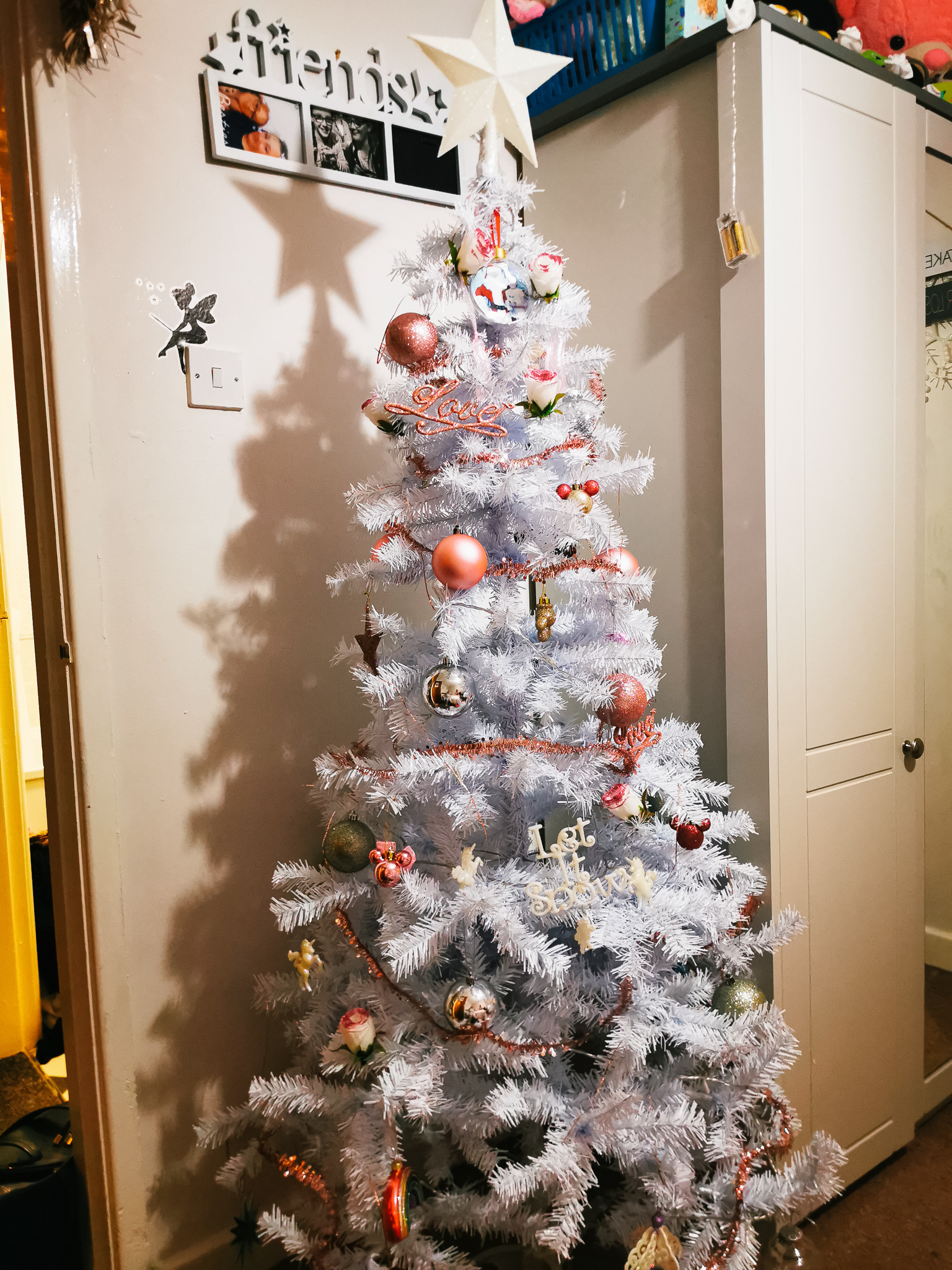 white xmas tree decorated with pink accessories
