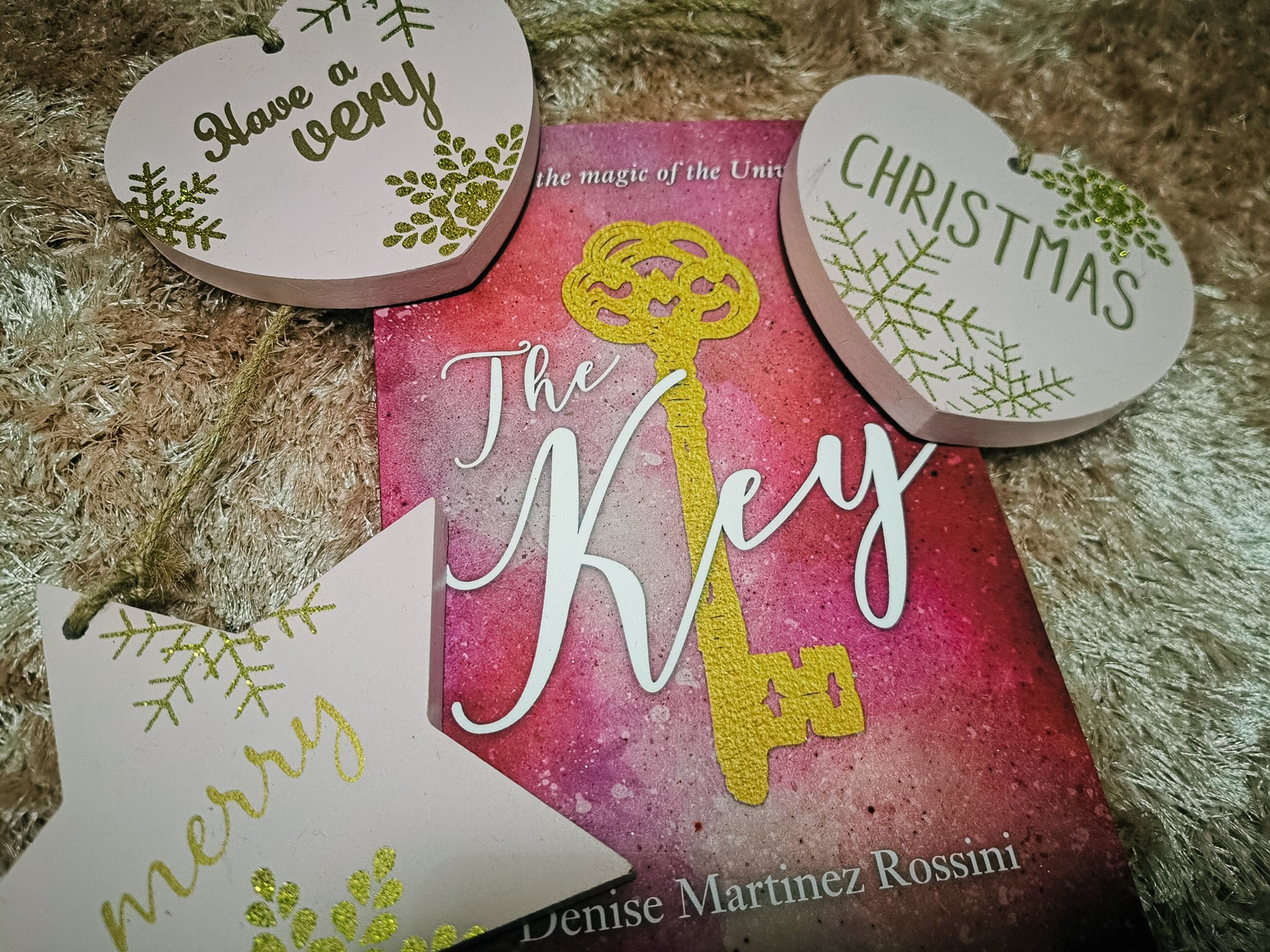 a pink book called the key in a christmas flatlay