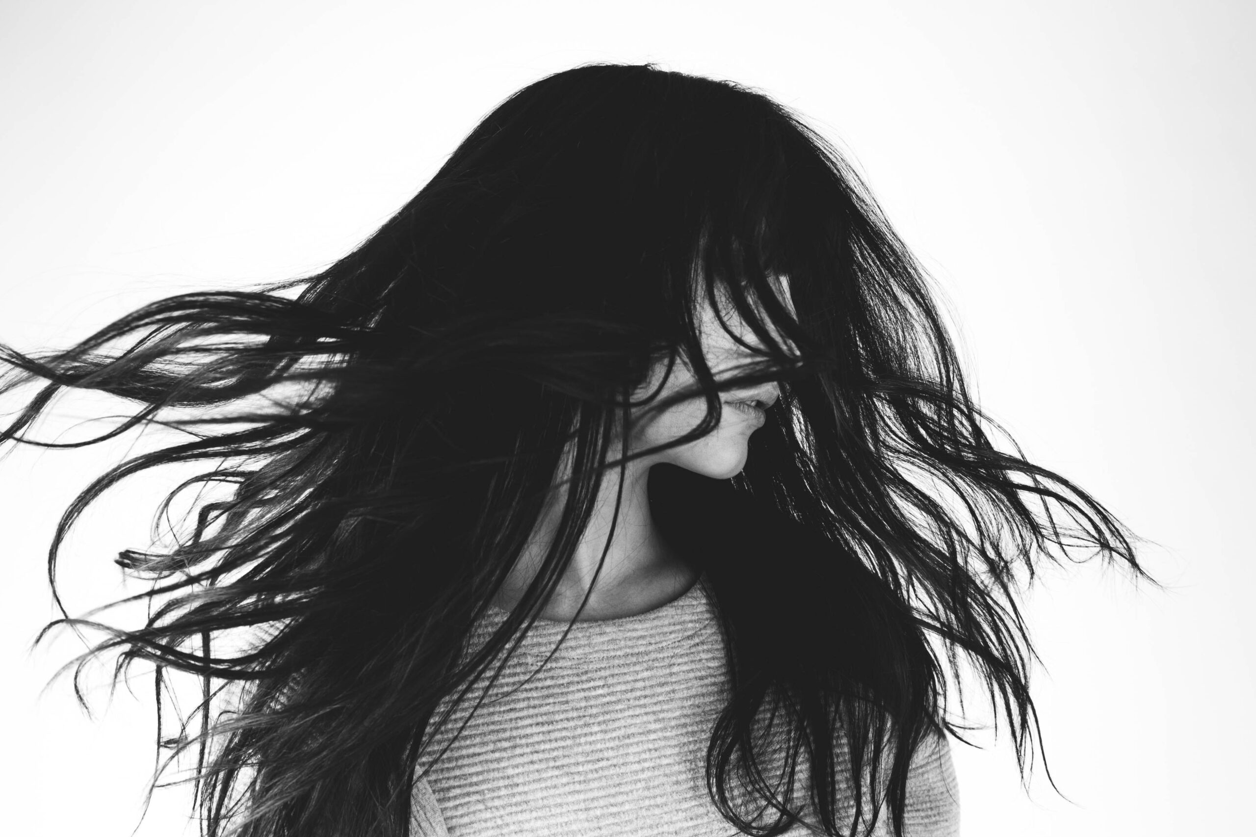 black and white image of a girl flicking her hair around her face