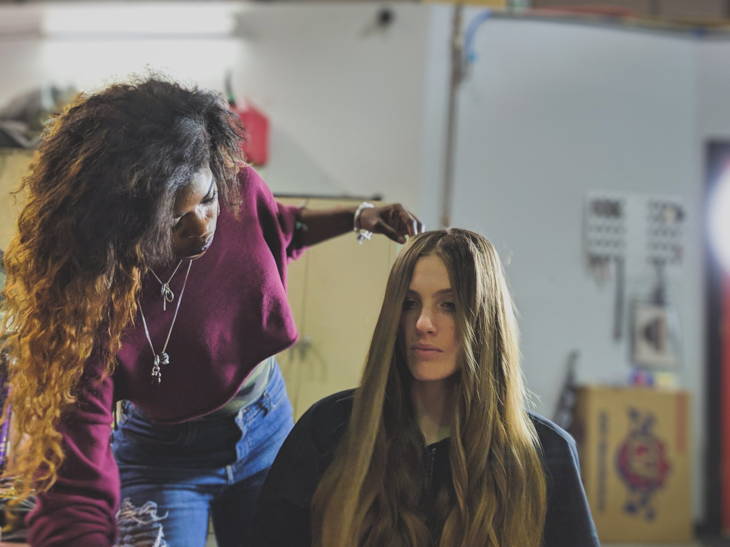 woman with long hair sitting in sa chair having her hair styled