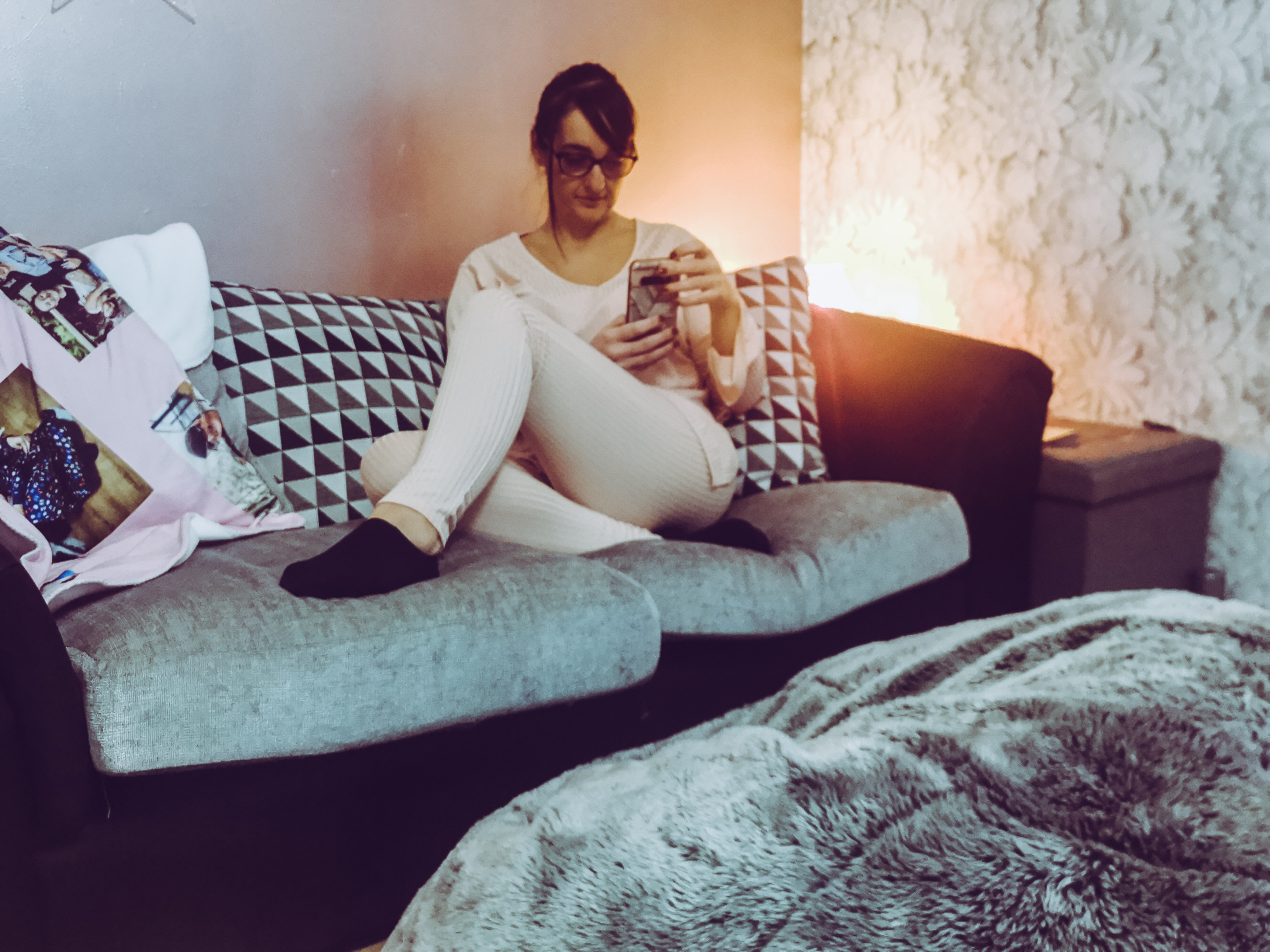 woman sitting on a sofa in a pink loungewear set