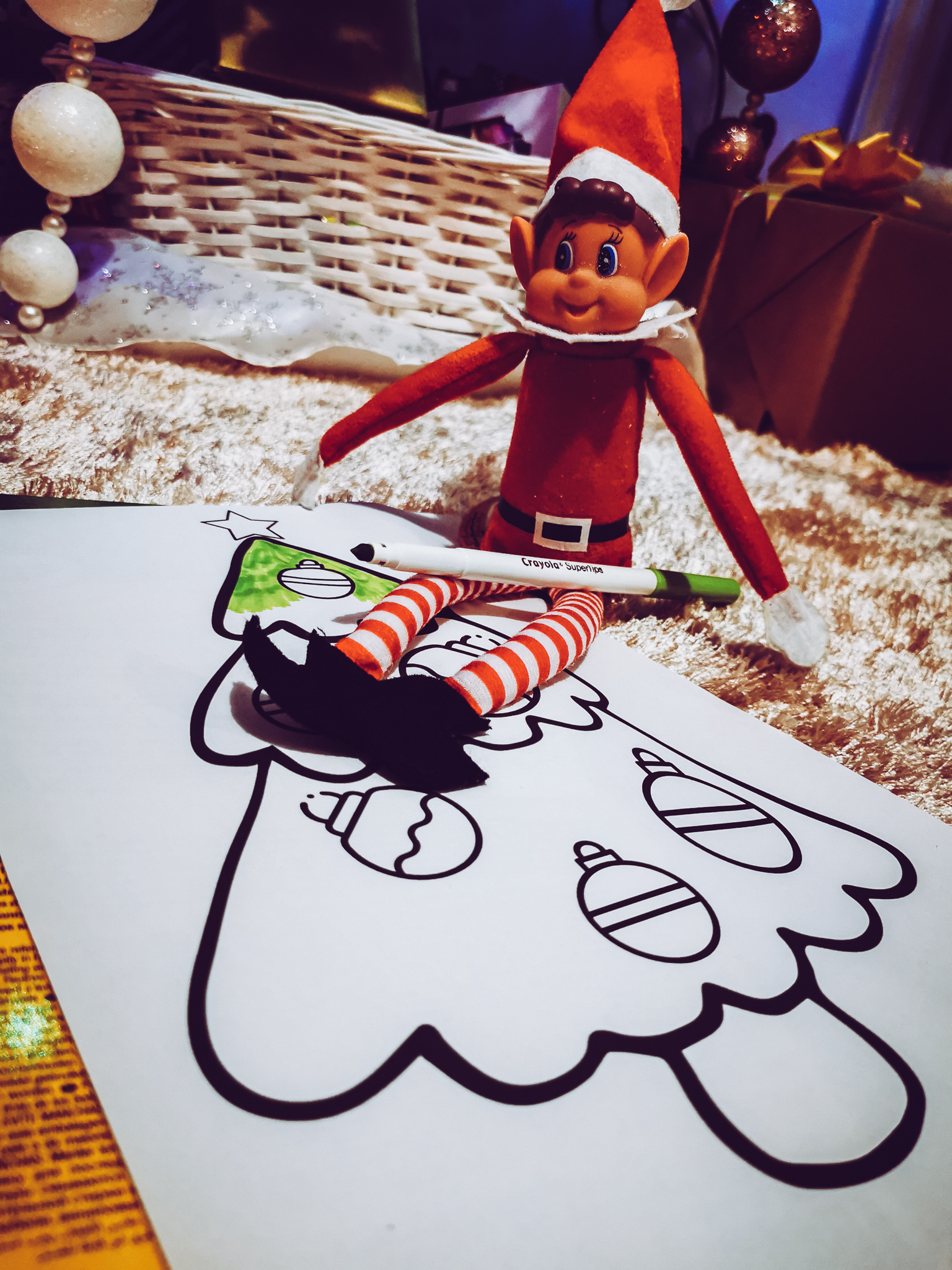 an elf sat on a colouring in sheet