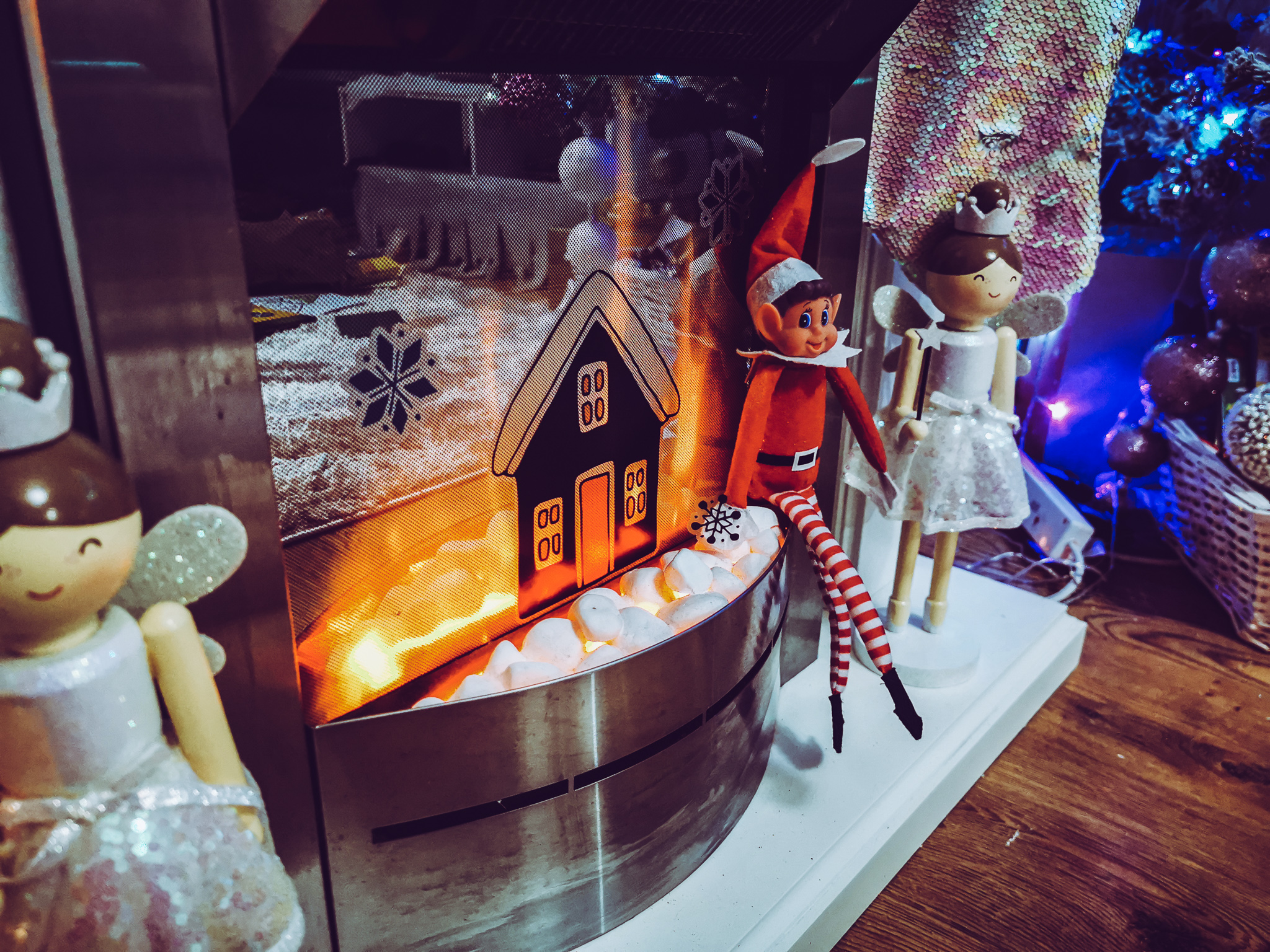 an elf sat on a fireplace with window stickers