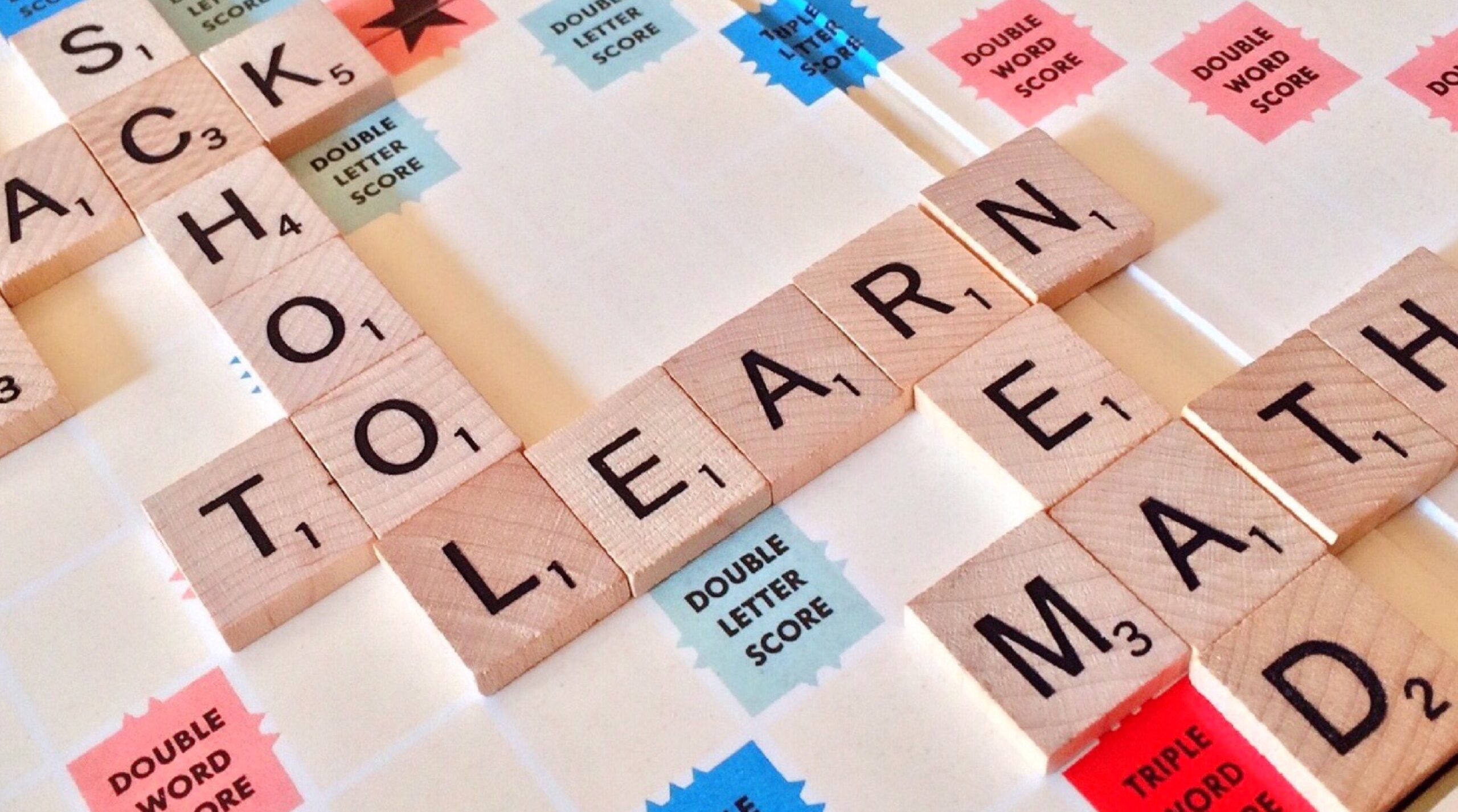 scrabble board with the words learn, read, math, school in broen blocks