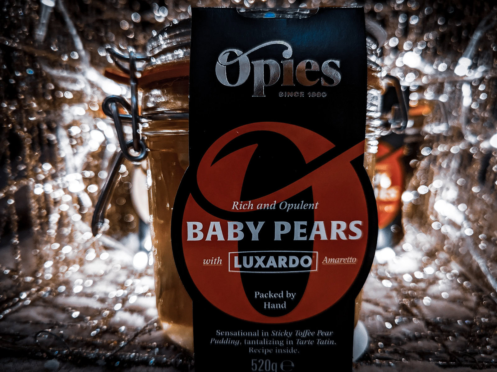 opies baby pears in amaretto with white fairy lights blurred in the background