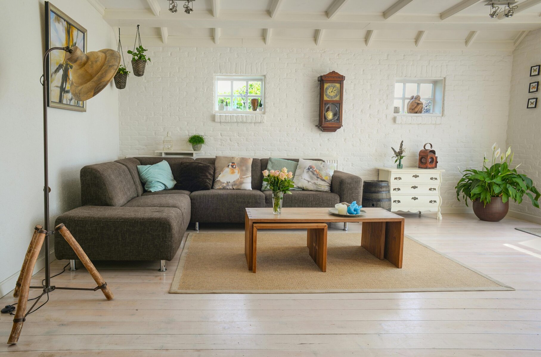 an mageof a living room set up with a corner sofa, coffee table and decor on a wooden floor