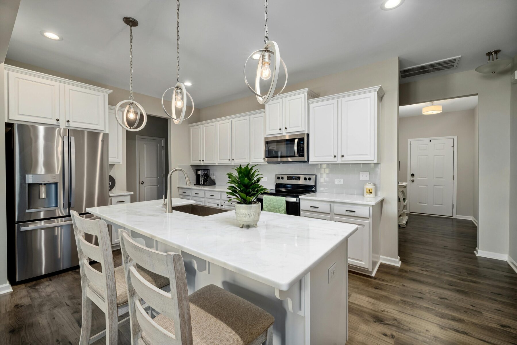 a photo of a modern white kitchen with a rectangle island