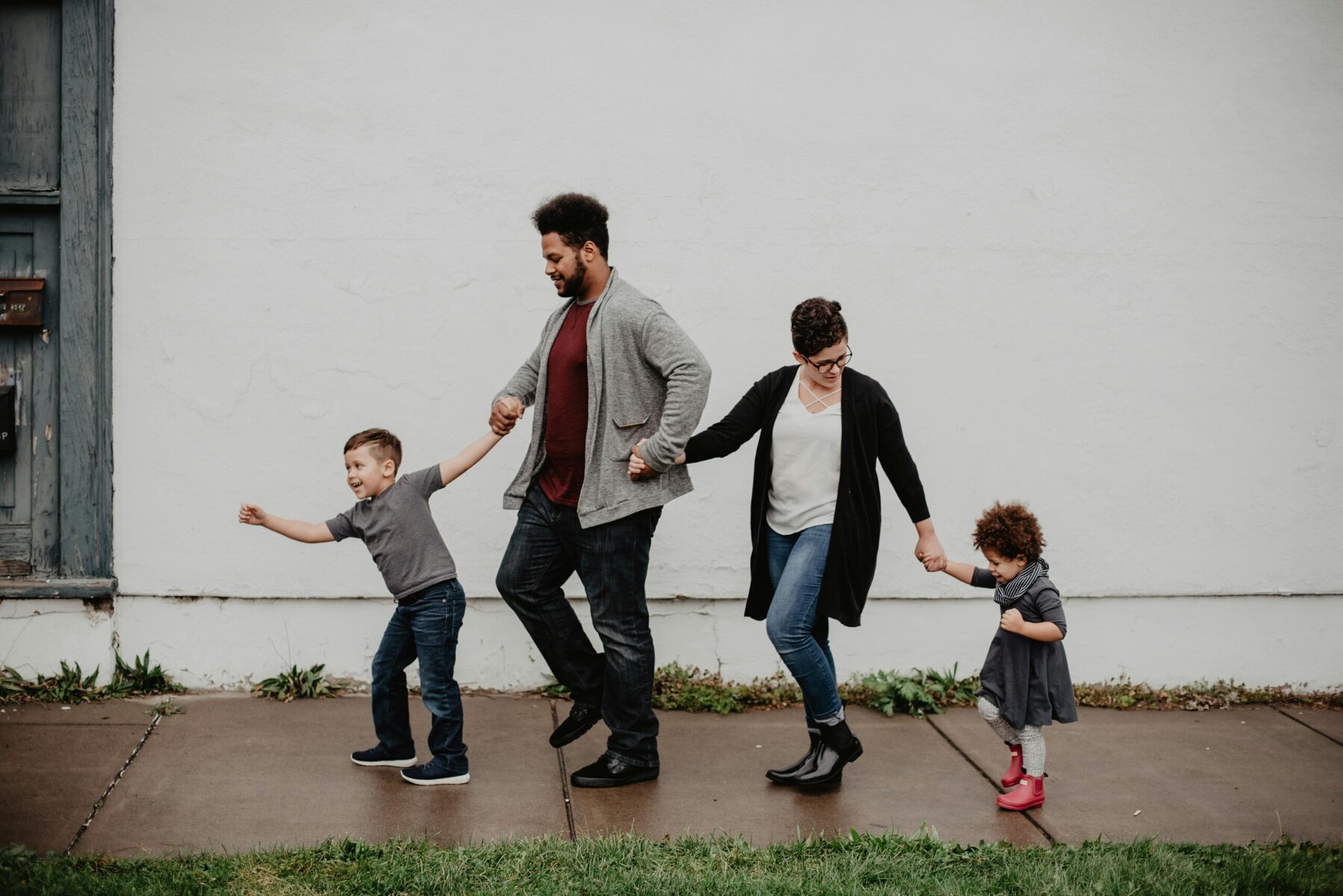 “Happy family outing, two kids walking with adults on pavement”