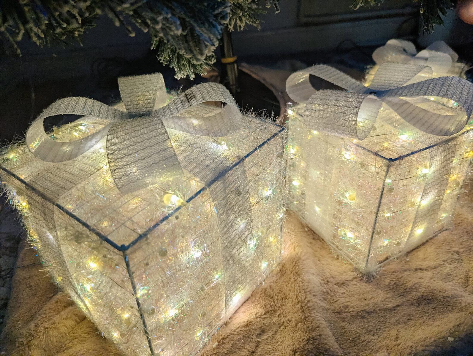 a view from above the quntis light-up present boxes in white when placed under a tree