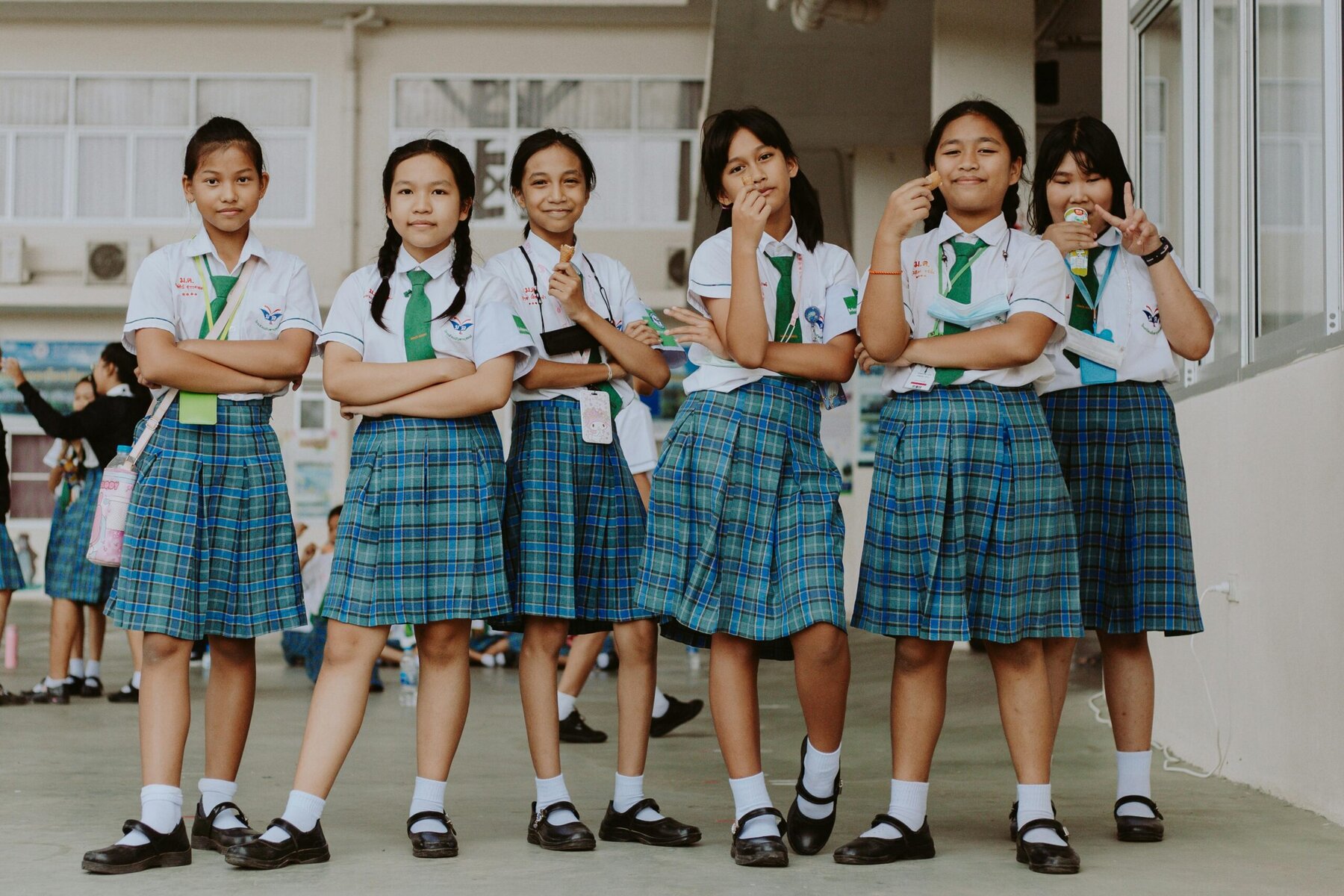 Group of school students standing together outdoors in matching uniforms.