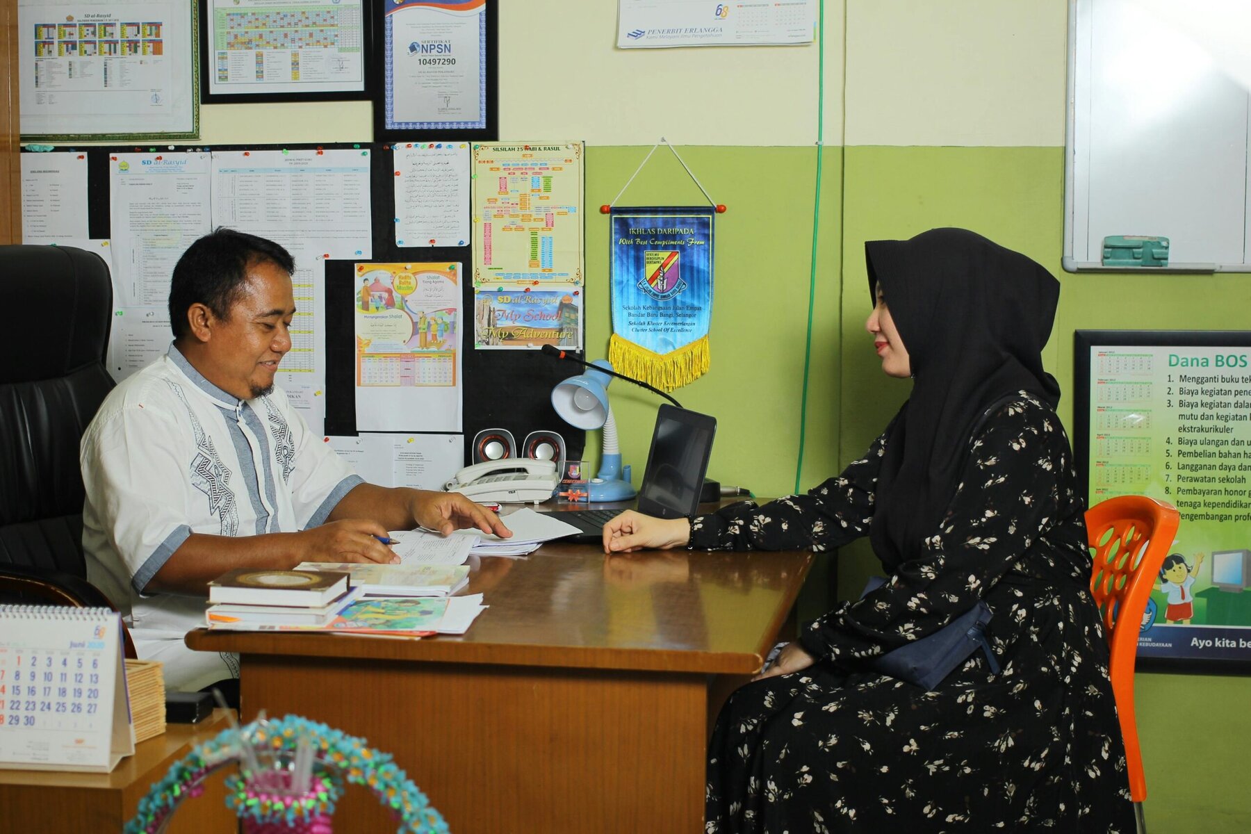 Teacher and parent discussing school matters in a school office