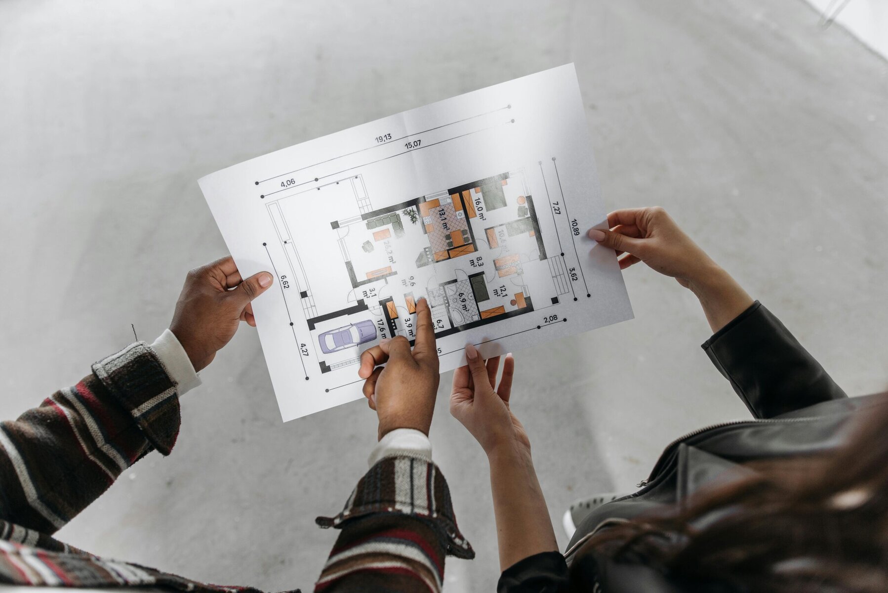 Couple holding a house blueprint planning their future home