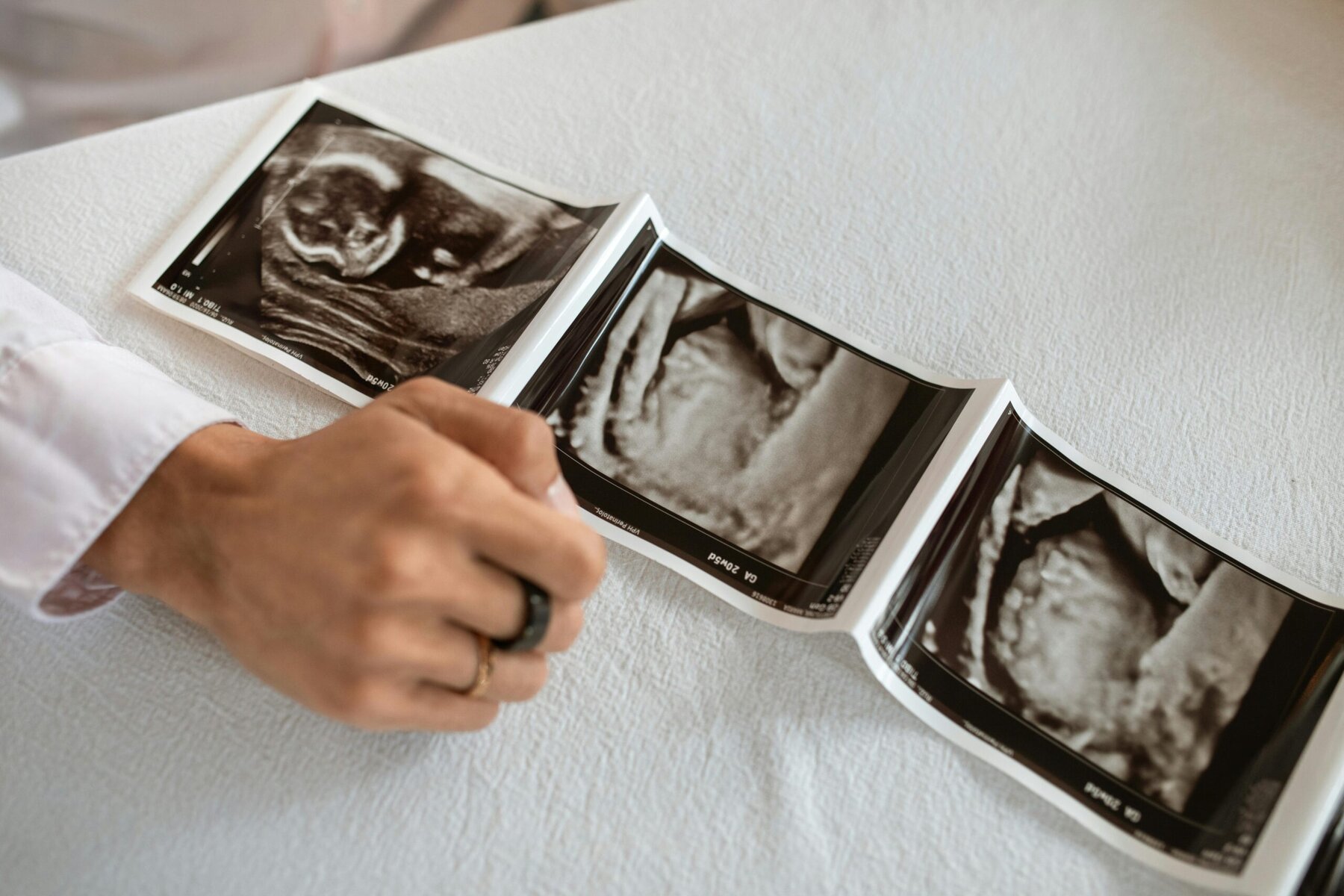 pregnant person holding a photo frame while sitting indoors