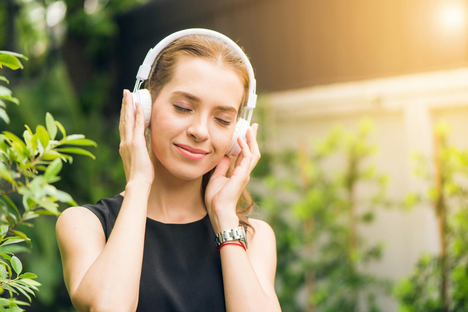 Woman holding white headphones, symbolising protecting hearing and safe listening habits