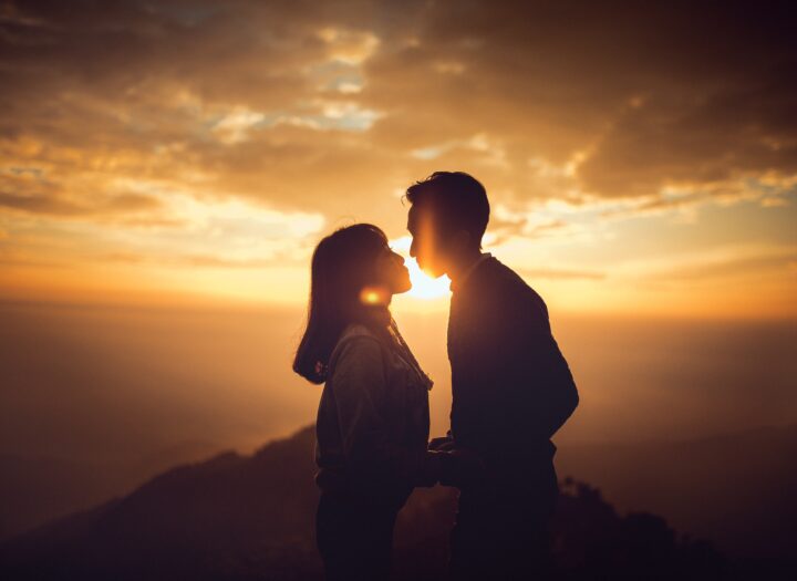 Silhouetted couple standing together at sunset in a mountain landscape