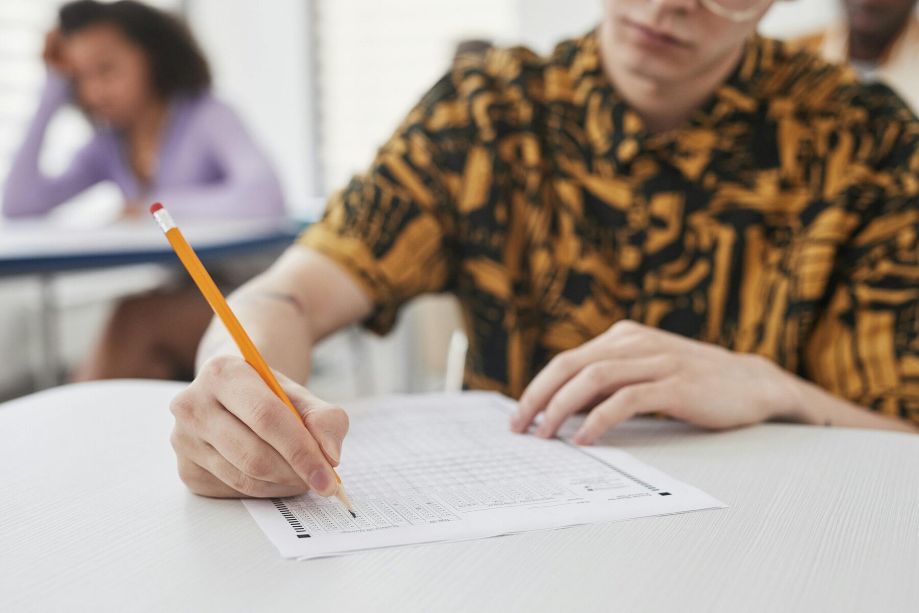 Person holding a pencil over a notebook ready to write