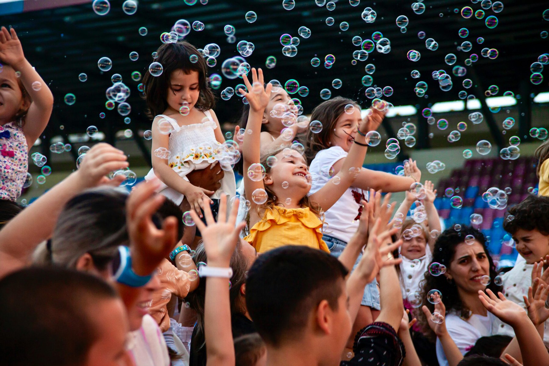 Group of children outdoors enjoying playing with bubbles at a festival