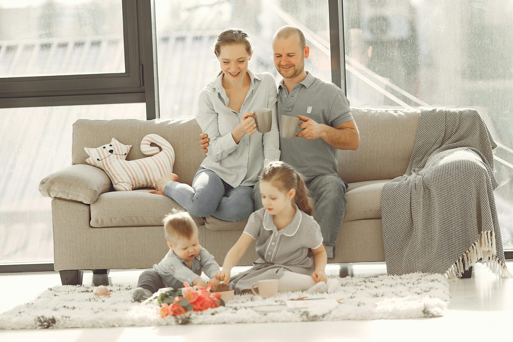 Happy family playing together in a living room at home, showing a relaxed family-friendly living space