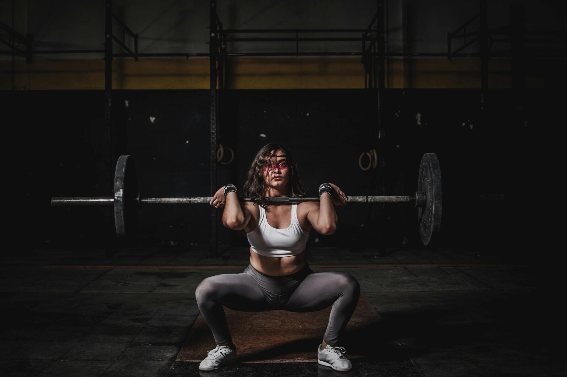 Woman lifting a barbell during strength training workout in a gym