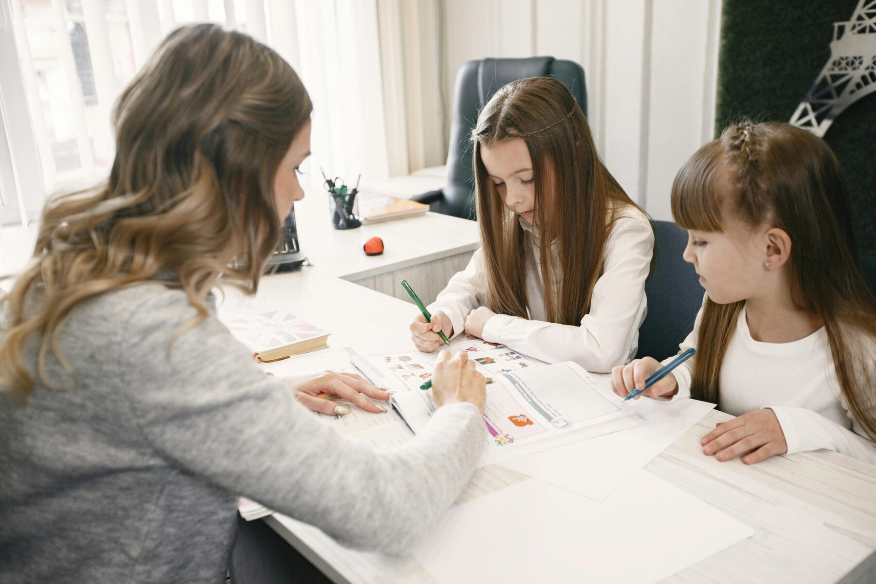 its is the private uttor one08:27Claude responded: A female tutor explains a textbook to two young girls at a bright white desk during a one to one tutoring sessionA female tutor explains a textbook to two young girls at a bright white desk during a one to one tutoring session