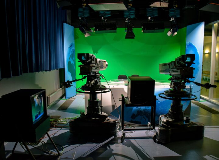 Green screen studio setup with lighting equipment for chroma key filming
