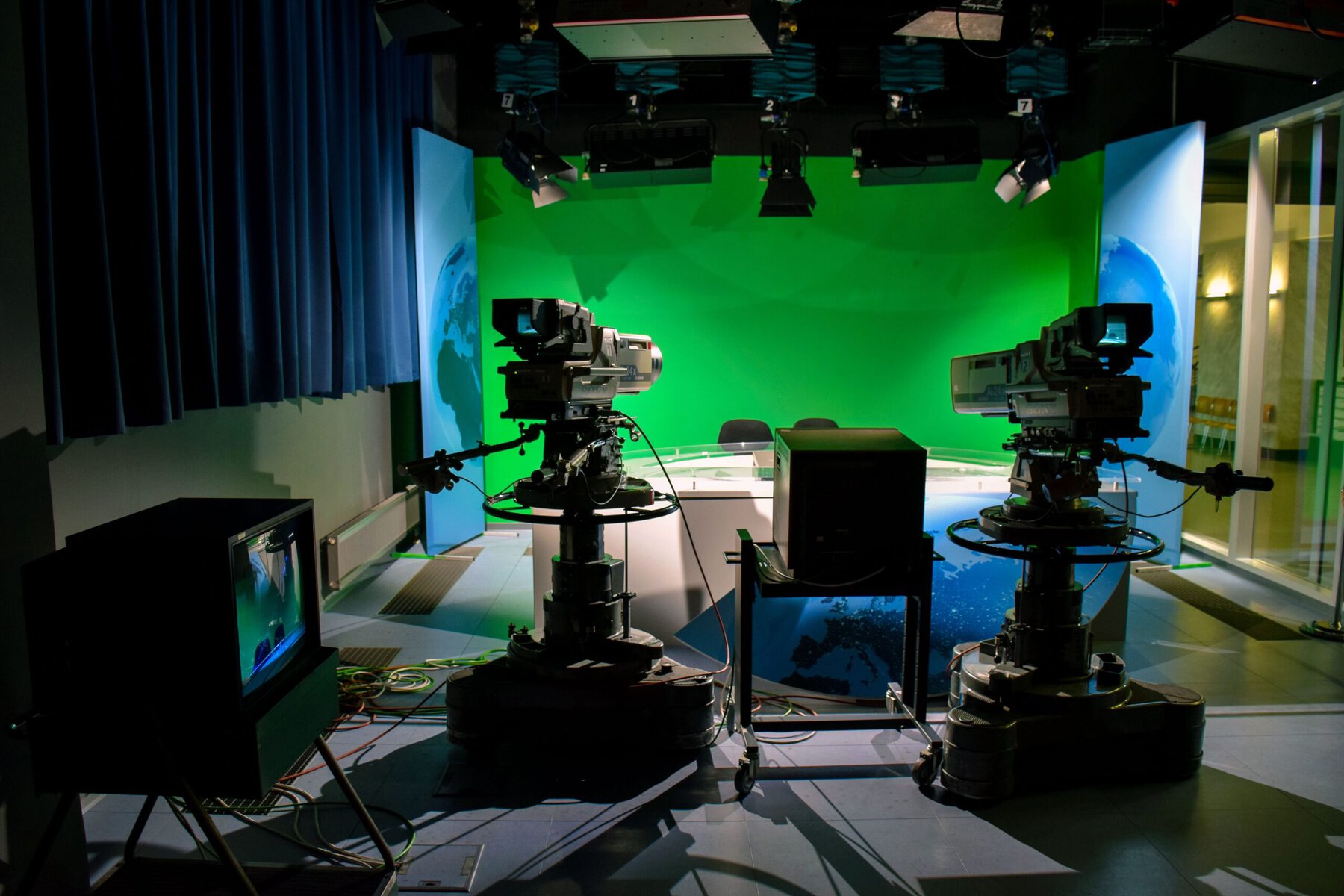 Green screen studio setup with lighting equipment for chroma key filming